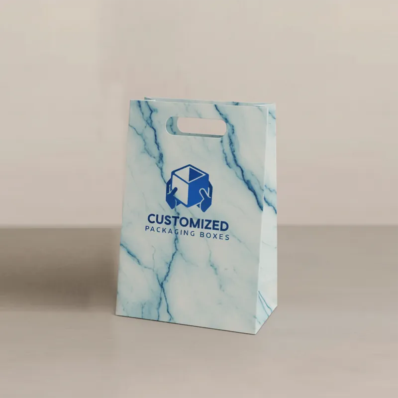 A folded branded gift bag with rope handles, showcasing a modern, minimalist design in a boxy style.