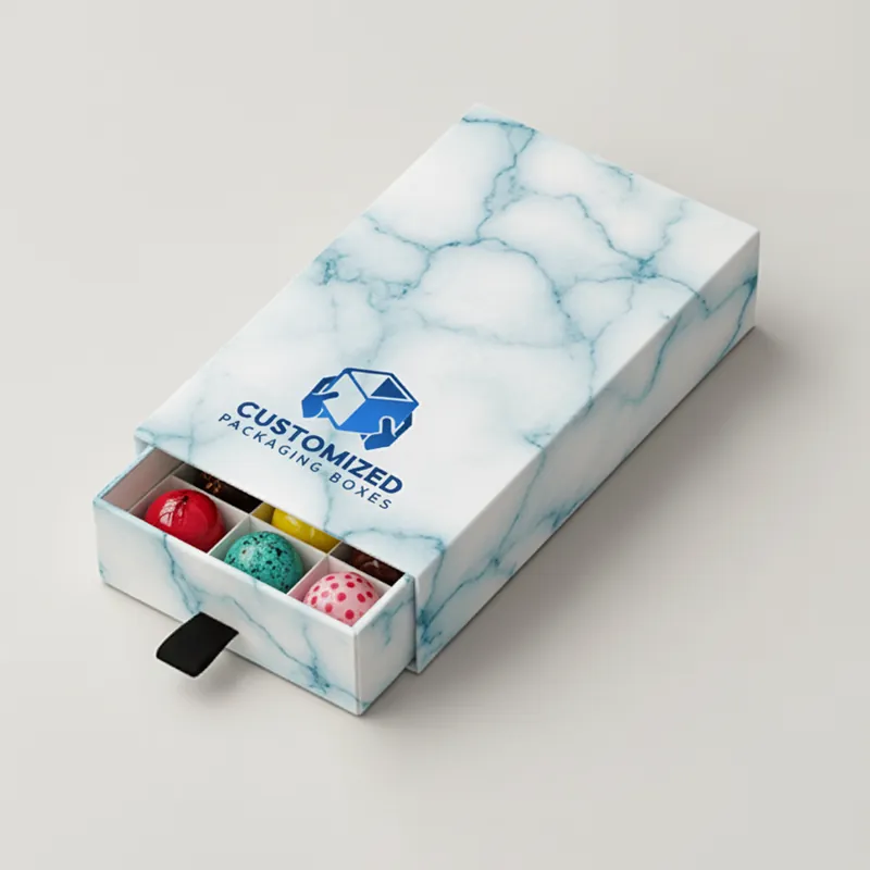 A rectangular bonbon box with a patterned design and a variety of colorful candies visible inside.
