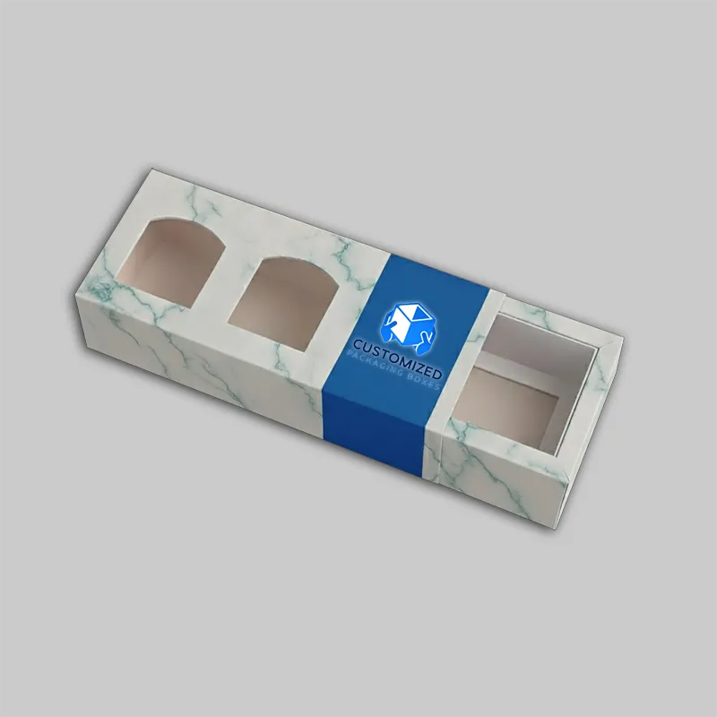 A candle box with a clear window displays the candle inside, showcasing the product and packaging design.
